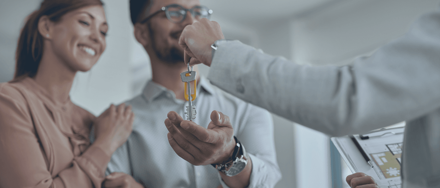 Casal feliz recebendo as chaves do novo imóvel